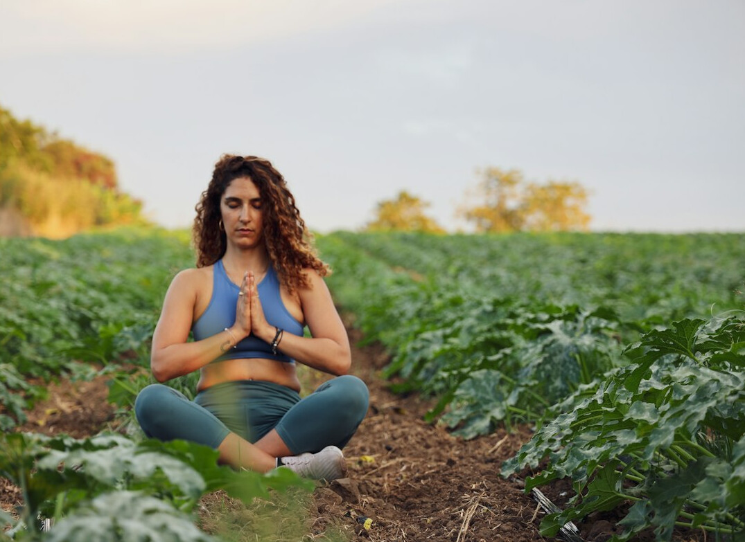 Woman meditating outdoors with eyes closed